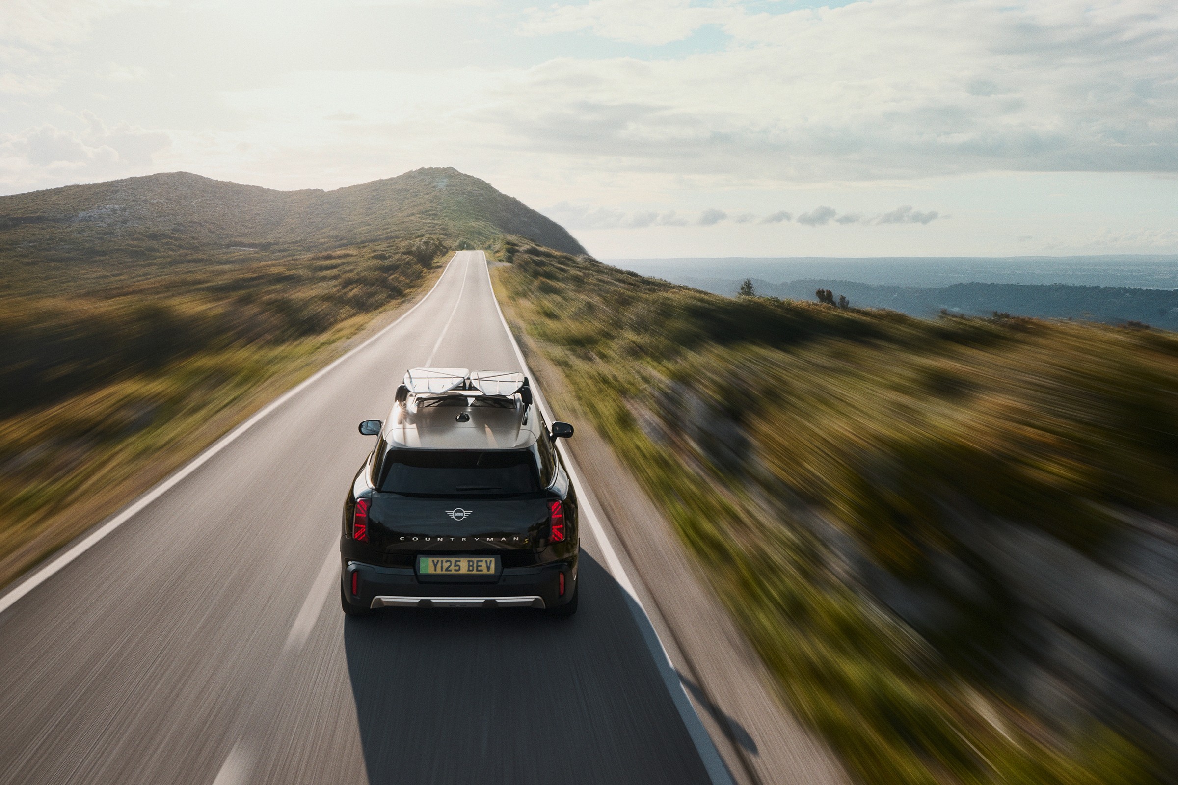 Mini Countryman a circular na estrada, com vista traseira e paisagem natural  envolvente